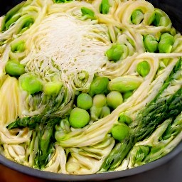 a pan of pasta primavera with salt, black pepper, olive oil, and grated parmesan cheese.