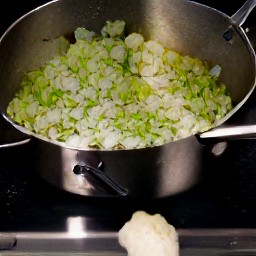 a saucepan containing butter, olive oil, leek slices, chopped cauliflower, minced garlic, and dried thyme.