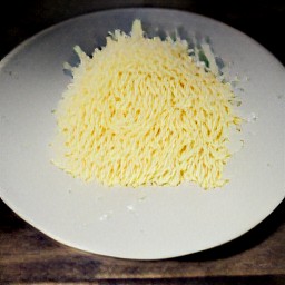 the grated gruyere cheese is transferred to a plate.