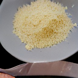 the grated parmesan cheese is transferred to the plate.