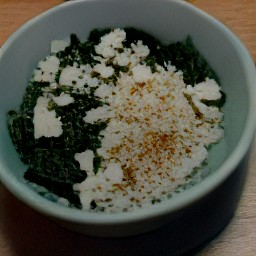 a bowl of chopped onion, dried spinach, lemon juice, crumbled feta cheese, spearmint, dried dill, breadcrumbs, beaten eggs and toasted pine nuts that have been mixed together