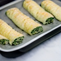 the pastry rolls are placed on a baking tray.