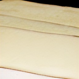 the puff pastry roll is cut into three pieces.
