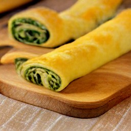 this action will result in sheets of puff pastry being filled with the spinach mixture and rolled.