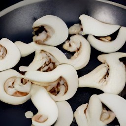 a stir-fried dish containing white mushrooms, ginger, and sesame seeds.