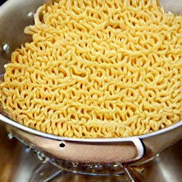 the egg noodles are drained in a colander.