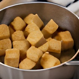 the tofu peanut sauce is stirred with a wooden spoon and the heat is turned off.