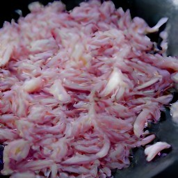 a wok full of peanut oil and shallots that have been stir-fried for 3 minutes.