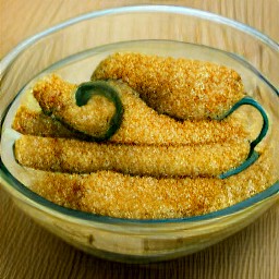 a bowl of water-dipped, breaded-stuffed jalapeno peppers.