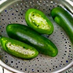 jalapeno peppers that are rinsed with cold water and then drained in a colander.