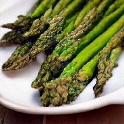 grilled asparagus on a platter with balsamic vinegar.