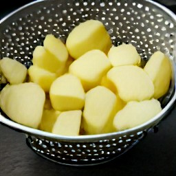 potatoes that have been rinsed under cold water and drained in a colander.