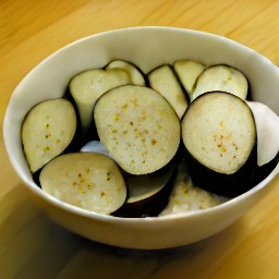 a bowl of eggplant mixed with salt and pepper.