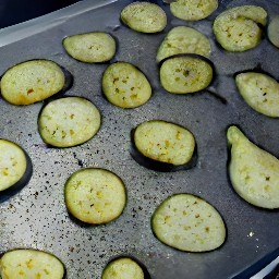 the salted eggplants are transferred to a baking sheet and drizzled with olive oil.