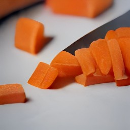 after peeling the garlic and onion, they are chopped. the carrot, celery, and parsley are then finely cut.