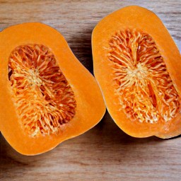 the peeled butternut squash is cut in half.