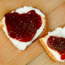 the strawberry jam is divided into the crackers and spread with a knife.