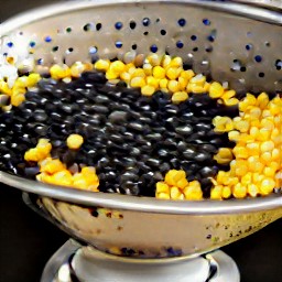 sweet corn and black beans that are rinsed and drained in a colander.