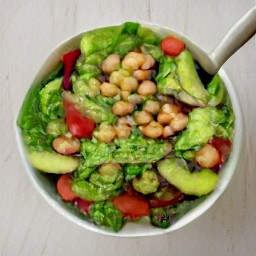 the dressing poured into the bowl, creating a chickpea and avocado salad.