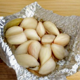 the trimmed garlic is placed in an aluminum foil and drizzled with 1 tbsp of olive oil.