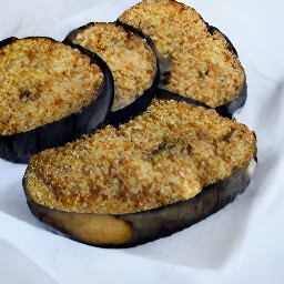 the eggplants are transferred to a paper towel using a slotted spoon.