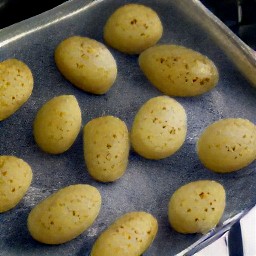 the dried potatoes are now on a baking sheet with olive oil over them.