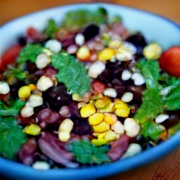 a bowl of mixed beans, corn, tomato, cilantro, and diced red onions.