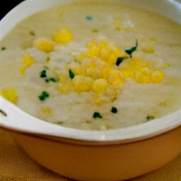 the corn and potato chowder is transferred to a serving bowl and garnished with chopped scallions.