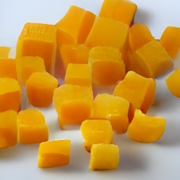 the cheddar cheese is cut into small squares.