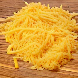 the cheddar cheese in small pieces after being shredded with a grater.