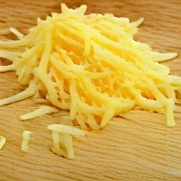 the cheddar cheese is shredded into small pieces.
