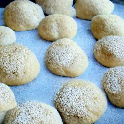 the dough rolls are placed into pans.