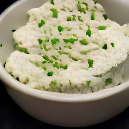 a bowl of cream cheese mixture with chives, spring onion, spearmint, cucumber, salt, and black pepper.