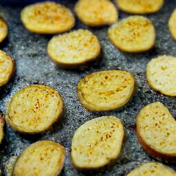 after flipping the potatoes, the user will then drizzle olive oil and salt over them.