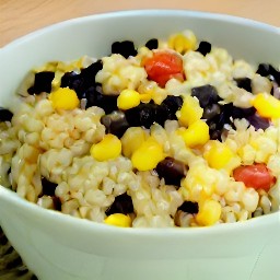 a bowl of black beans, corn, tomatoes, red onions, cilantro, jalapeno peppers and lime juice mixed together with olive oil, salt, black pepper and hot sauce.