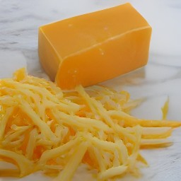 the cheddar cheese is shredded into small pieces.