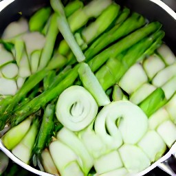 a pan of cooked garlic, onion, and asparagus.