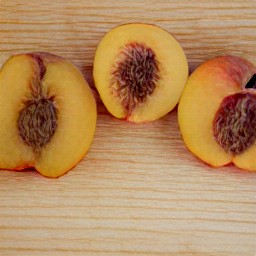 the peeled peaches are cut in half.