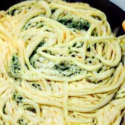 a dish of spinach, cream cheese, and spaghetti with olive oil, salt, and black pepper.