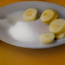 there granulated sugar and sliced bananas on a plate.