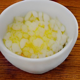 a bowl of chopped onions, mustard powder, ground ginger, soy sauce, and water that has been mixed for 2 minutes.