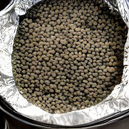 the onion mixture is poured into the dutch oven and stirred with a wooden spoon. the honey is added on top and covered tightly with foil.