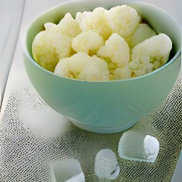 a bowl of boiled cauliflower with ice cubes added to stop the cooking process.