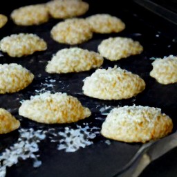 a cookie sheet with white chocolate and coconut cookies.