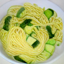 a bowl of spaghetti with scallions, cucumbers, paprika, and italian dressing mixed in.