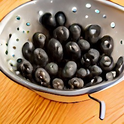 black olives that have been rinsed in a colander.