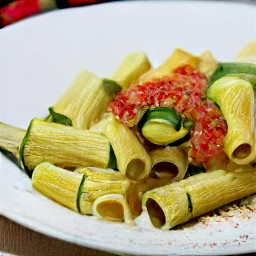 the rigatoni pasta is now in a bowl and is topped with tomato sauce.