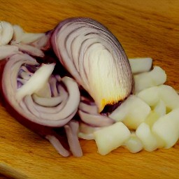 a bowl of chopped red onion, scallions, garlic, and oregano.