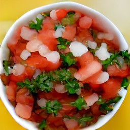 a bowl of chopped tomatoes, onions, garlic, jalapeno peppers, and cilantro mixed with lime juice and olive oil.