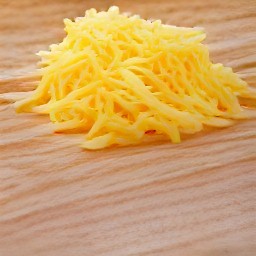 the cheddar cheese is shredded into small pieces.